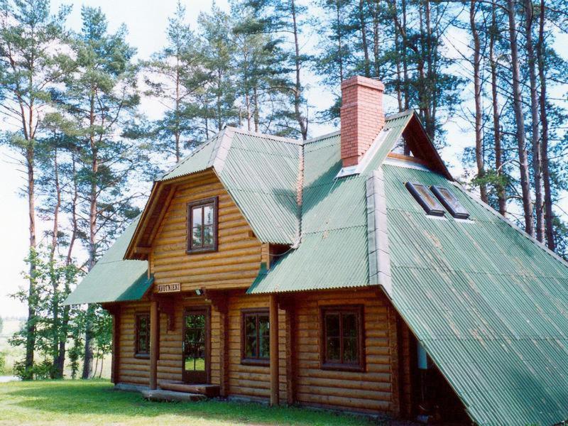 una pequeña casa de madera con techo de estaño en Avotnieki, en Dzērbene