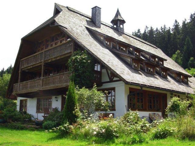 ein großes Holzhaus mit einem Gamer-Dach in der Unterkunft Talblickhof in Sankt Georgen im Schwarzwald