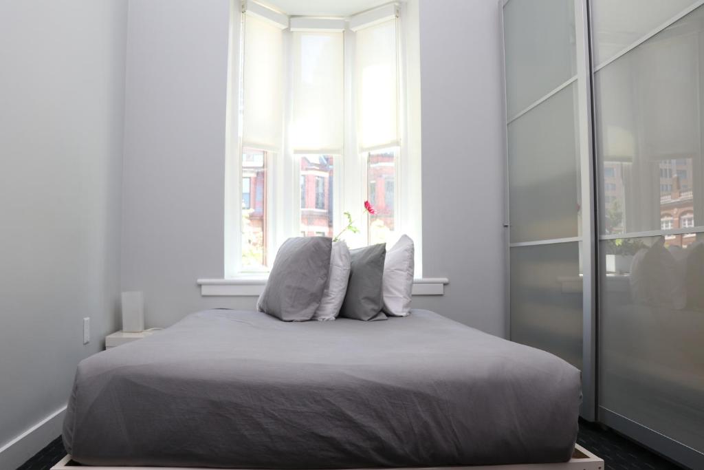 a bed in a white room with a window at Stylish Newbury Street Studio, #11 in Boston