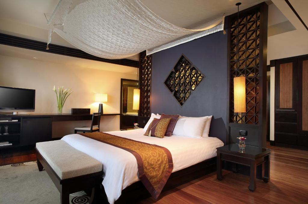 a bedroom with a large bed and a tv at Dusit Thani Laguna Phuket in Bang Tao Beach