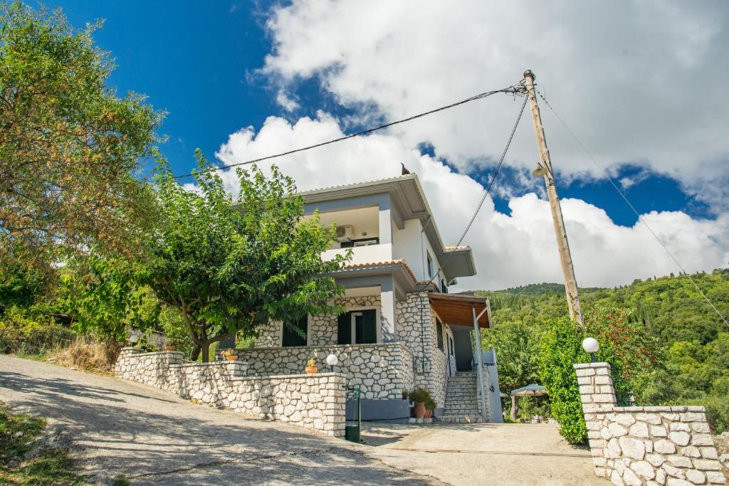 a house with a stone wall and a crane at Vafkeri Apartments in Vavkerí
