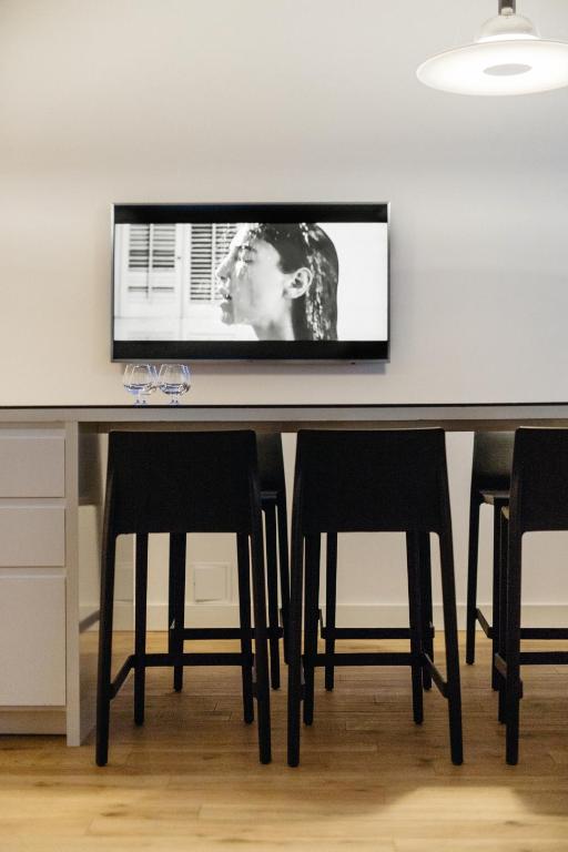 a table with chairs and a television on a wall at Islandijos gatvė in Vilnius