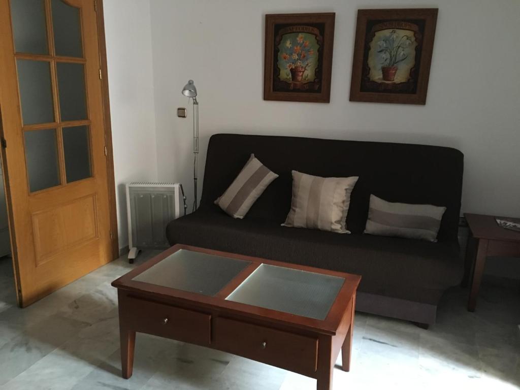 Sala de estar con sofá negro y mesa de centro en Apartamento céntrico en Ceuta