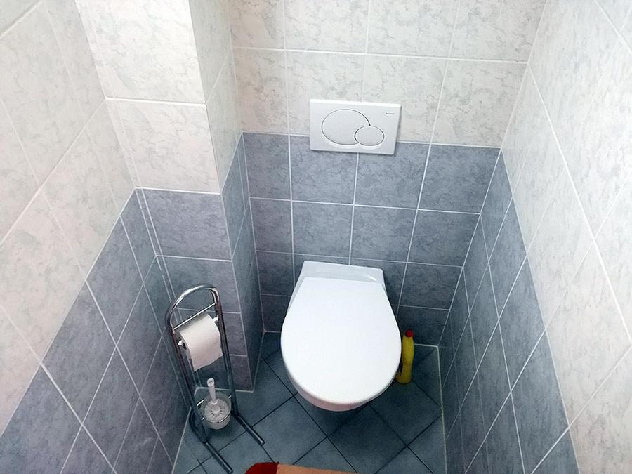 a bathroom with a white toilet in a tiled room at Apartmán Donovaly Šafrán 2 in Donovaly