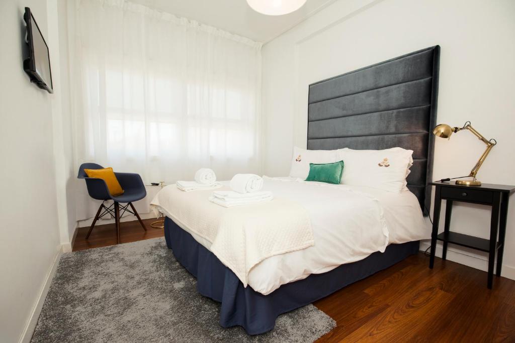 una camera con un grande letto con testiera nera di ML Apartments Charming Rooms a Porto