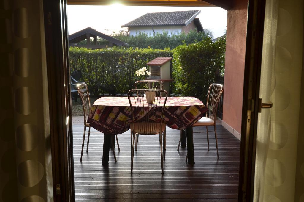 una mesa y sillas en un porche con mesa y sillas en Erno Apartment en Lesa