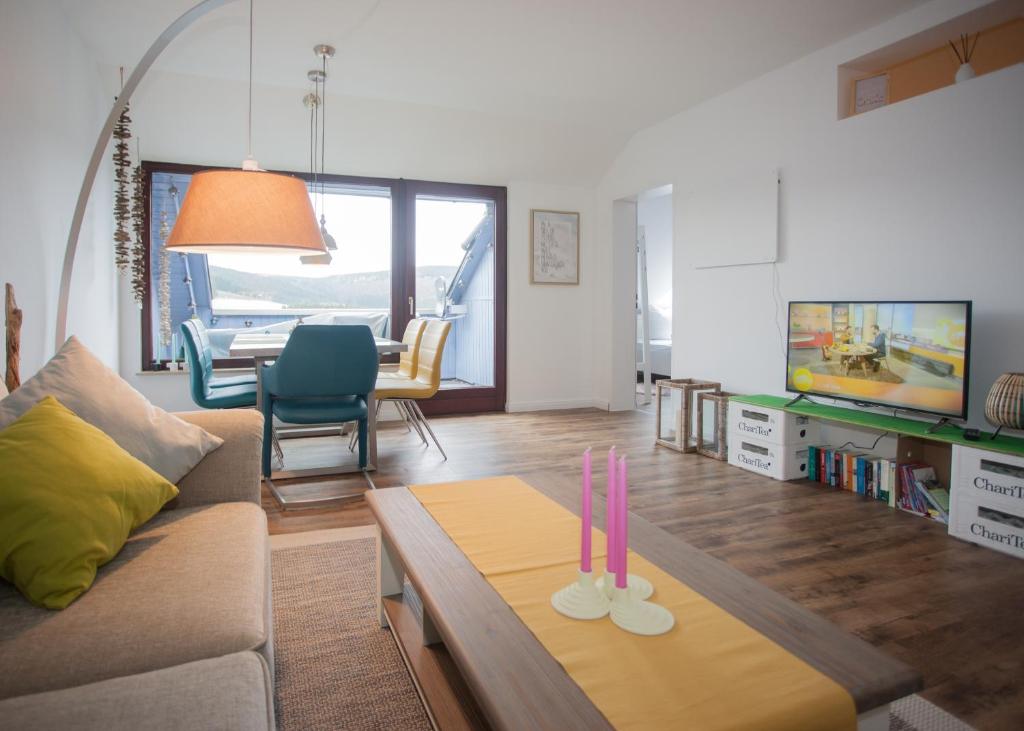 ein Wohnzimmer mit einem Sofa und einem Tisch mit zwei Kerzen in der Unterkunft Welcome in - Am Bergelchen 58-J in Winterberg