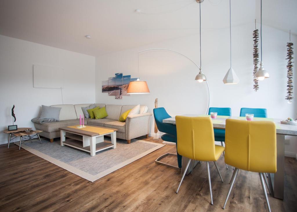 uma sala de estar com uma mesa e cadeiras amarelas em Am Bergelchen 58-J em Winterberg
