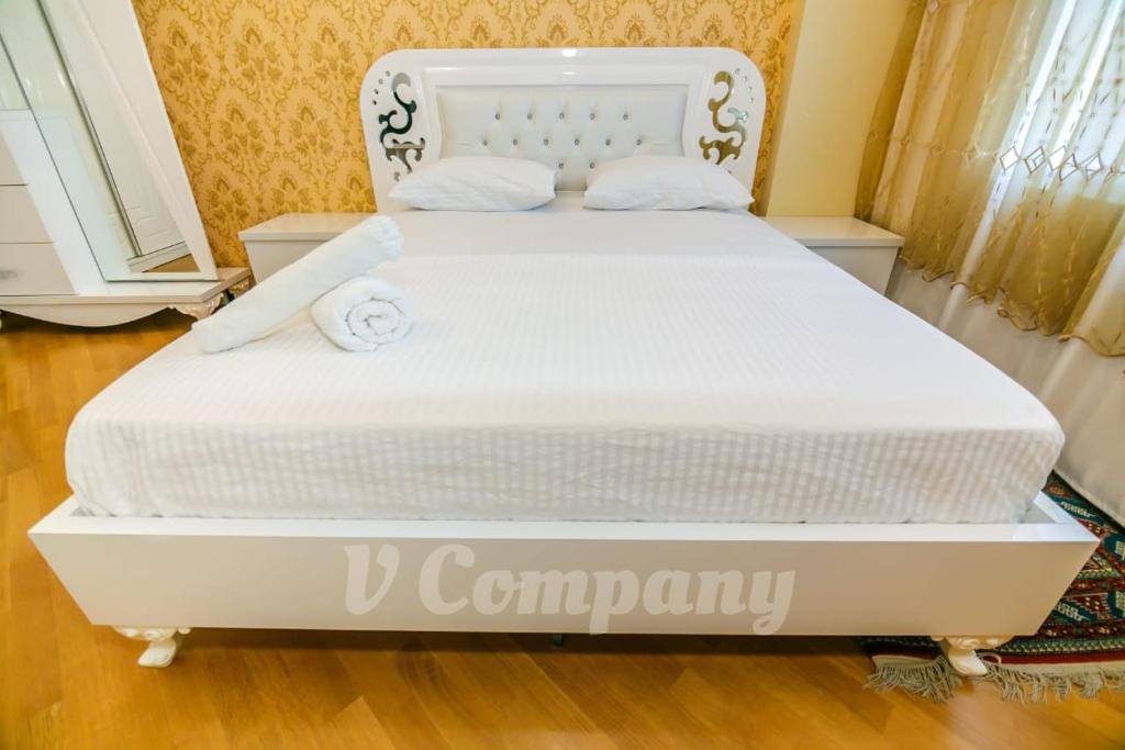 een wit bed met twee handdoeken erop bij Winter Garden Apartment in Baku