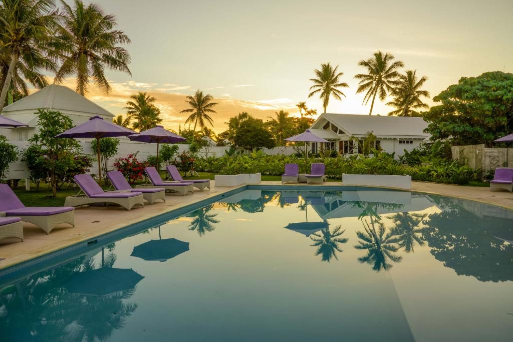 a pool with chairs and umbrellas at a resort at Tamanu on the Beach in Port Vila