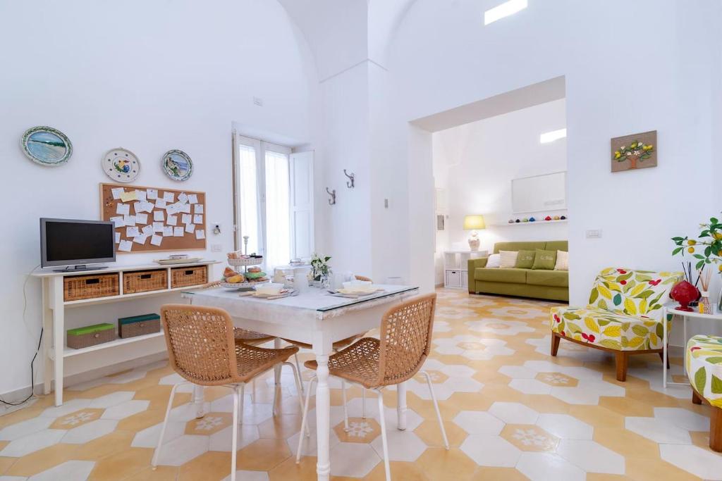un soggiorno con tavolo e sedie bianchi di Li Frati Casa Vacanze a Lecce