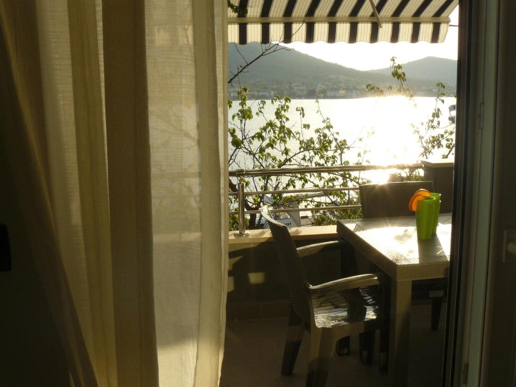 een kamer met een tafel en uitzicht op het water bij Apartments Selina in Vinišće