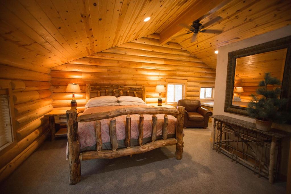 ein Schlafzimmer mit einem Bett in einer Blockhütte in der Unterkunft The Pines at Island Park in Island Park
