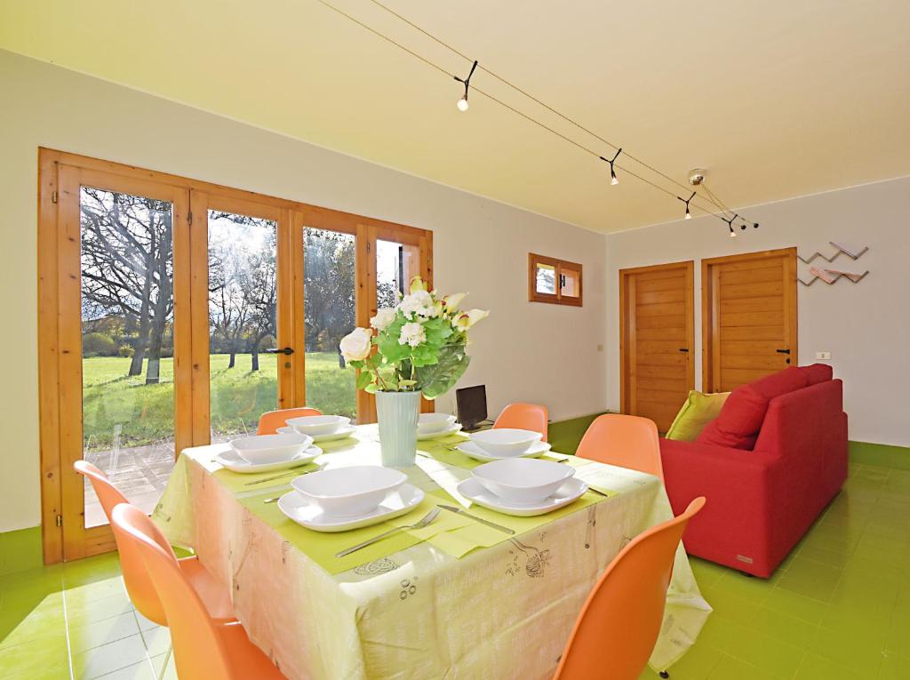 uma sala de jantar com uma mesa e um sofá vermelho em Design cottage Treviso em Treviso