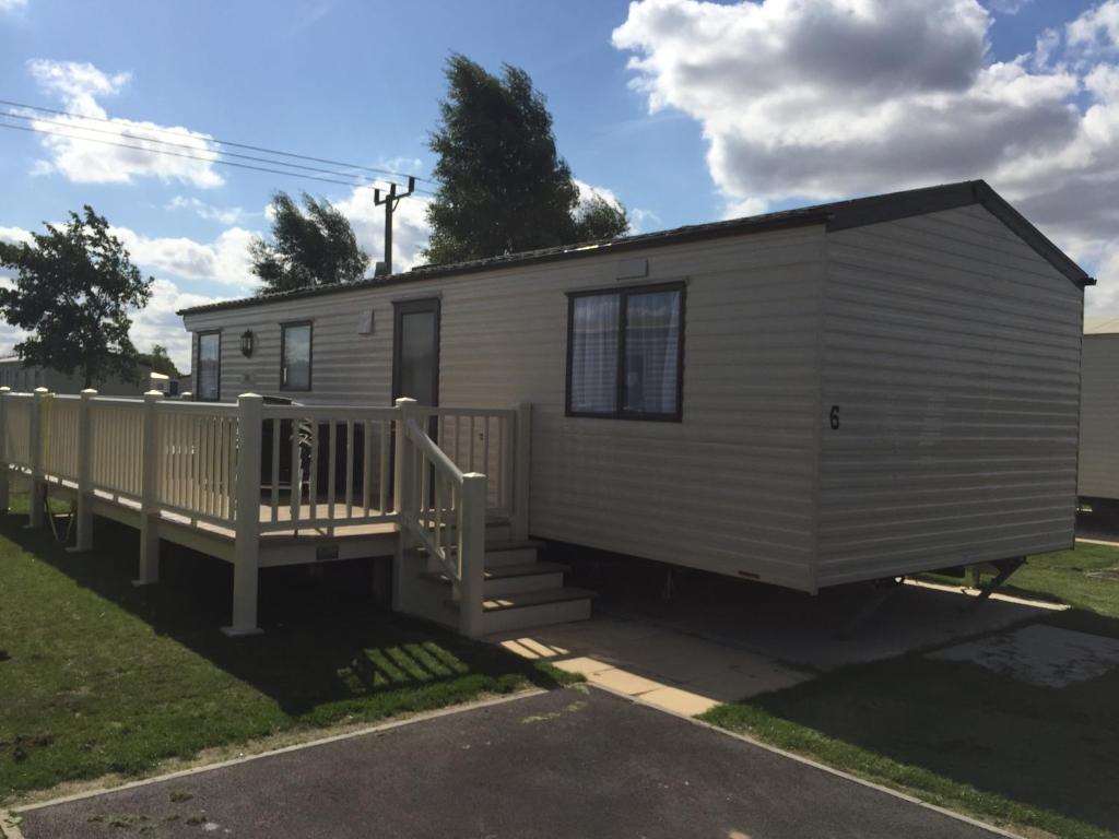 a tiny house with a porch and a deck at 2 and 3 Bedroom caravans with Hot Tubs at tattershall in Tattershall