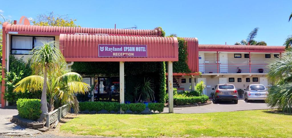 a hotel with cars parked in a parking lot at Rayland Epsom Motel in Auckland