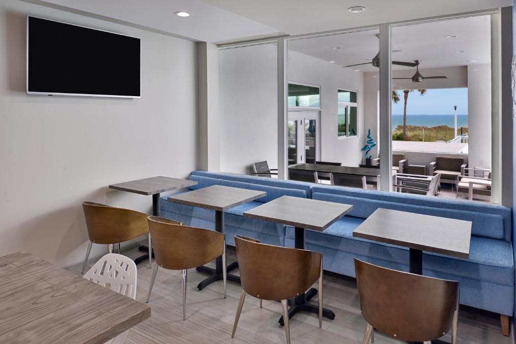 a restaurant with a blue couch and tables and chairs at Cabana Shores Hotel in Myrtle Beach