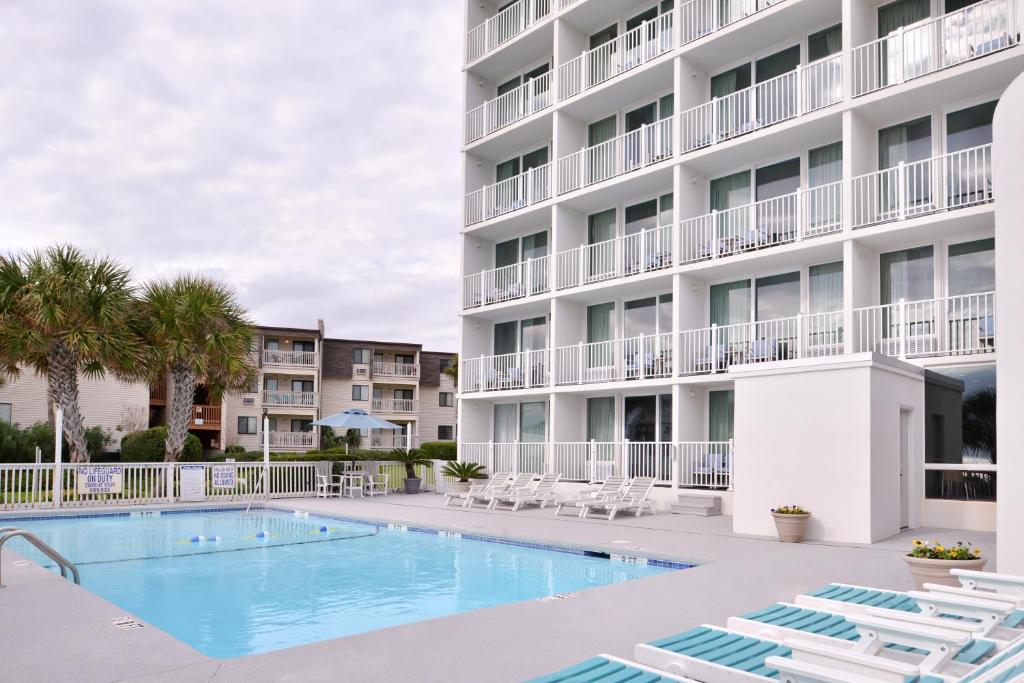 a swimming pool in front of a apartment building at Cabana Shores Hotel in Myrtle Beach