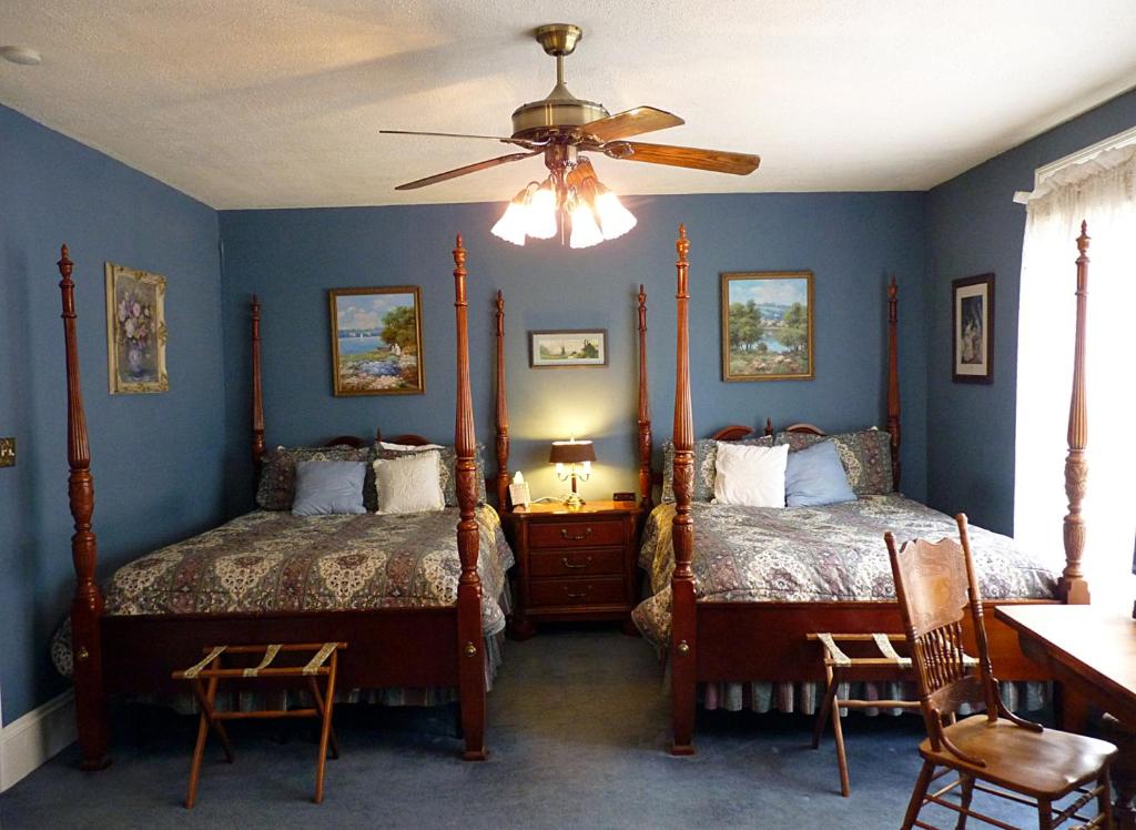 a bedroom with two beds and a ceiling fan at Strickland Arms Bed and Breakfast in Austin