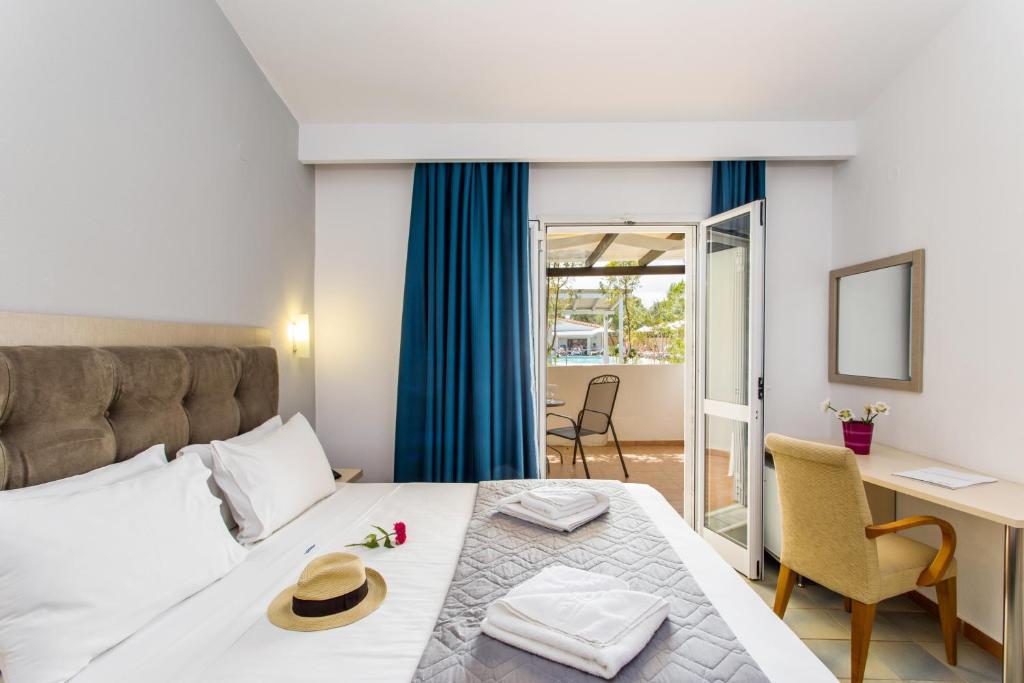 A bed or beds in a room at Coral Blue Beach Hotel Gerakini