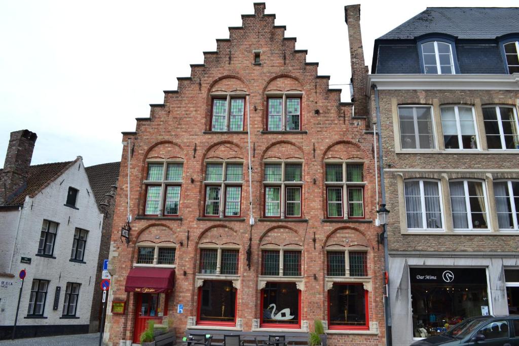 a large brick building with a clock on the side of it at Hotel Salvators in Bruges