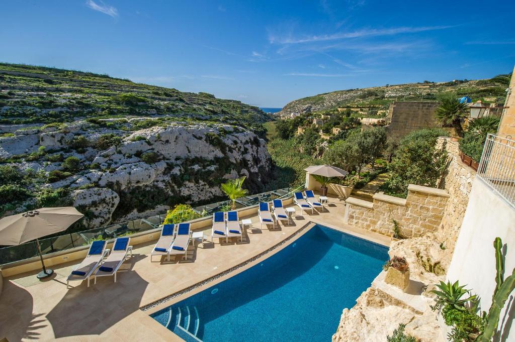 a beach area with a pool and chairs at Viewpoint Boutique Living in Xlendi