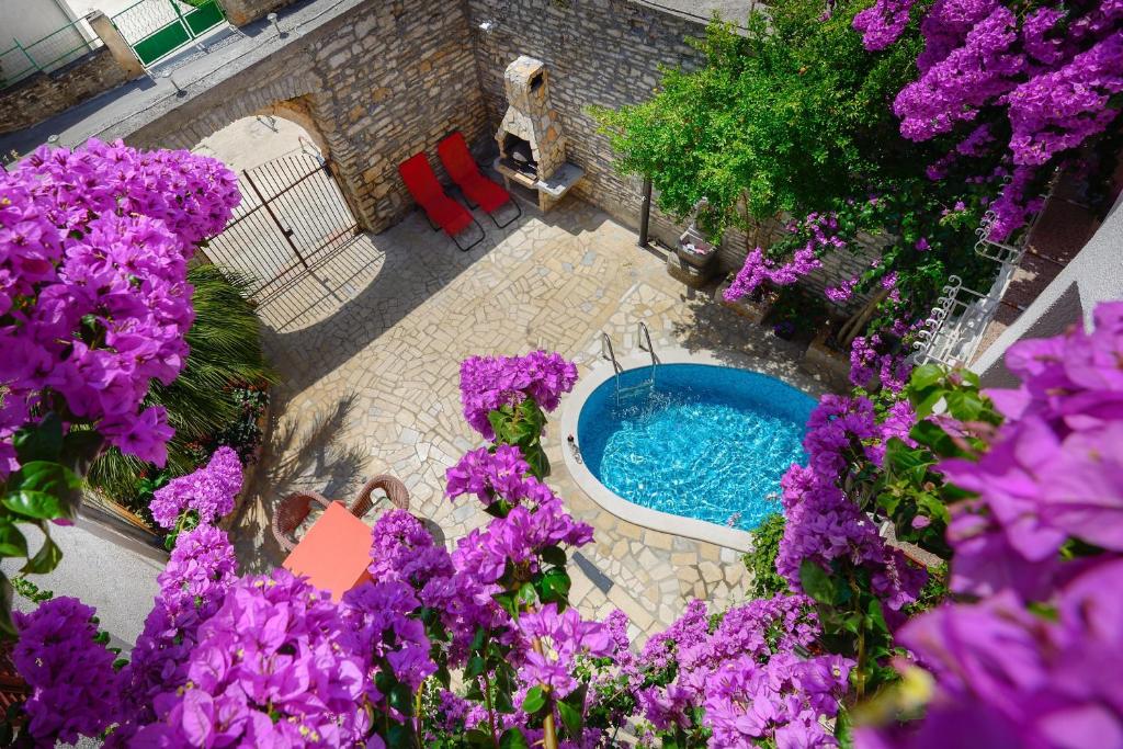 an overhead view of a swimming pool with purple flowers at Apartments Salčinović in Medulin