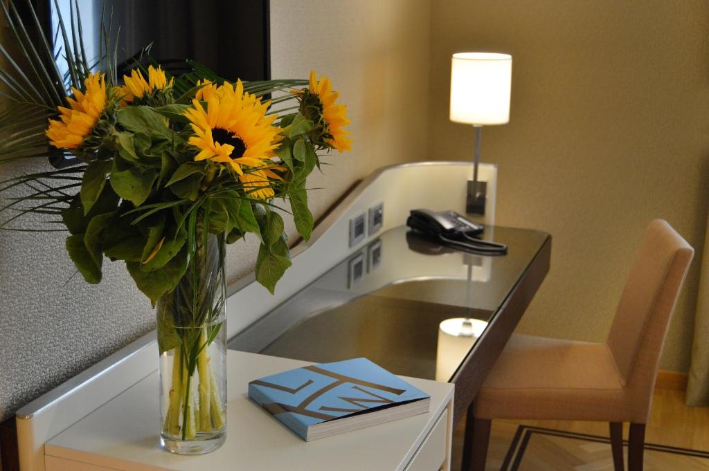 a vase filled with sunflowers sitting on a table at Palazzo Esedra in Naples