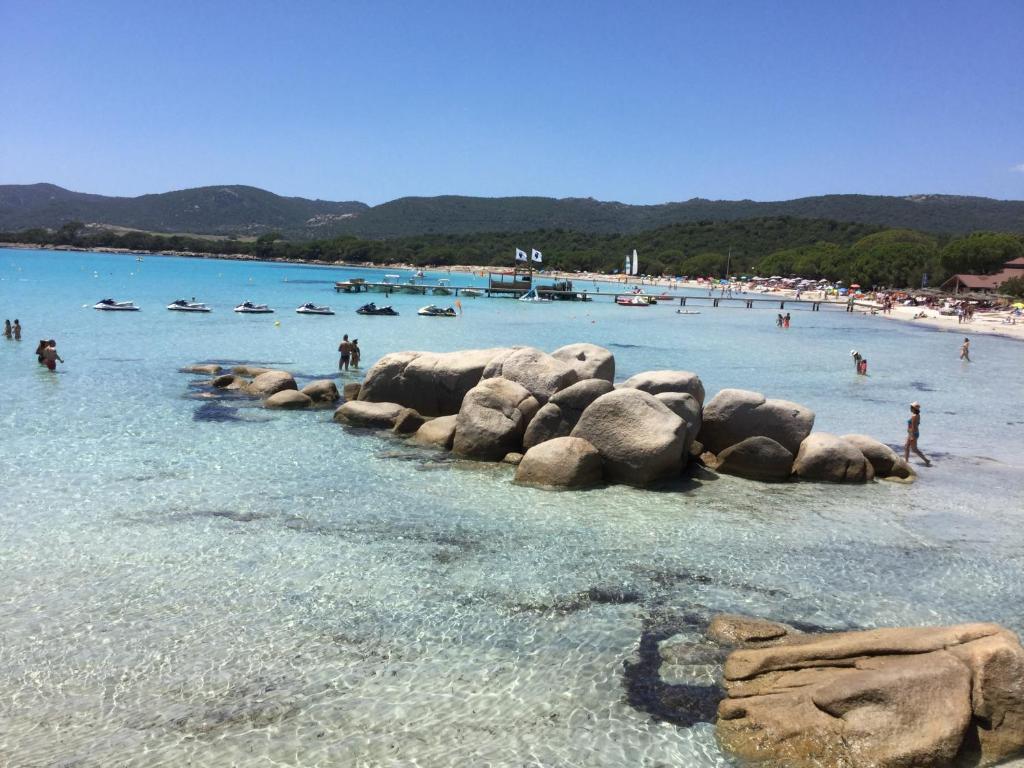 eine Gruppe von Menschen im Wasser an einem Strand in der Unterkunft Villa Les Hameaux Di Santa Giulia in Porto-Vecchio