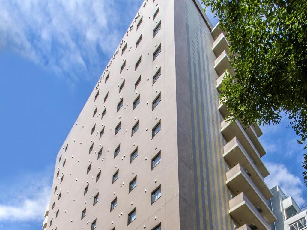 ein hohes Gebäude mit Seitenfenstern in der Unterkunft Meitetsu Inn Nagoya Kanayama Annex in Nagoya