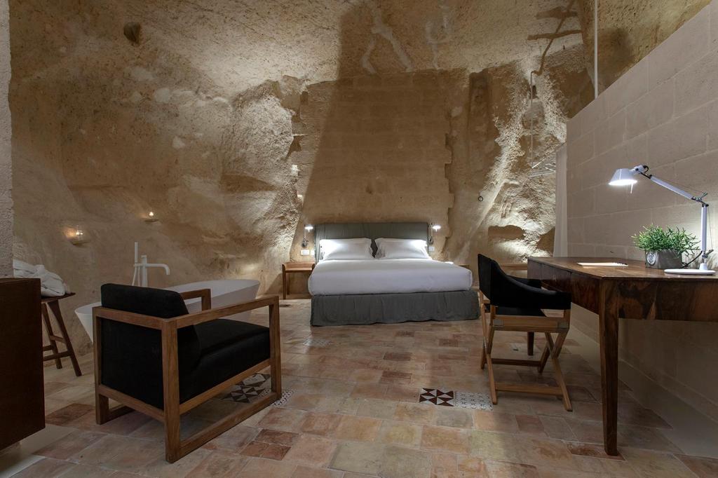 a bedroom with a bed and a desk and a desk at Conche Luxury Retreat in Matera
