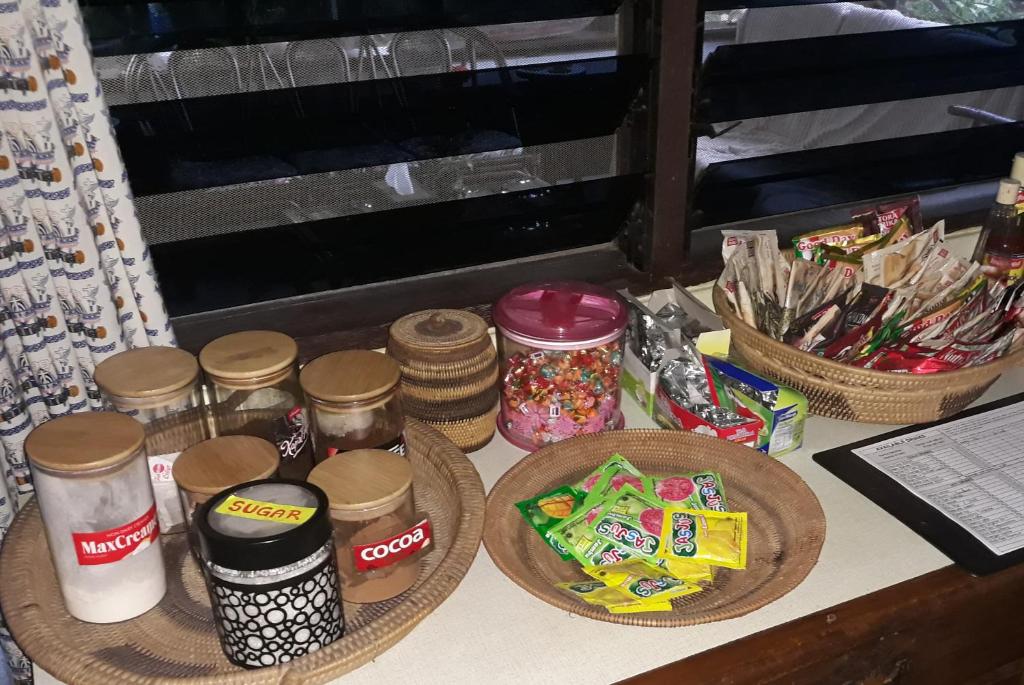 a table topped with jars of food and snacks at Homestay Galpera Papua in Jayapura