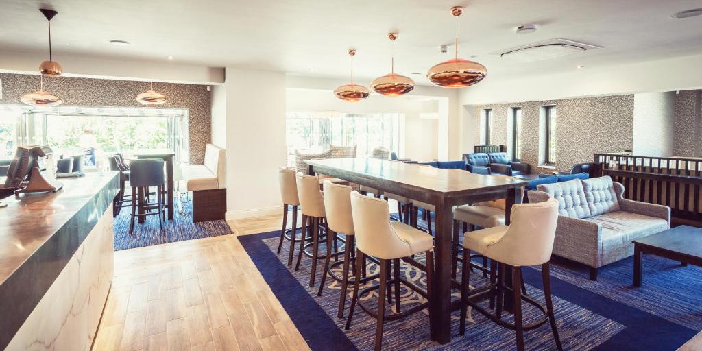 a dining room with a table and chairs at The Residence Hotel at The Nottinghamshire Golf & Country Club in Nottingham