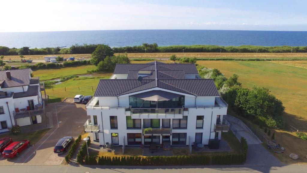 an aerial view of a house with the ocean in the background at Haus Calmsailing in Börgerende-Rethwisch