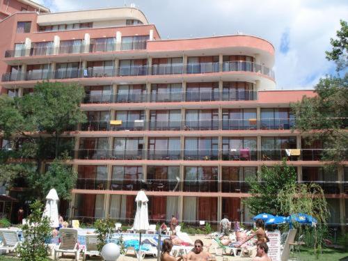 un gran edificio con gente sentada frente a él en Jupiter Hotel, en Sunny Beach