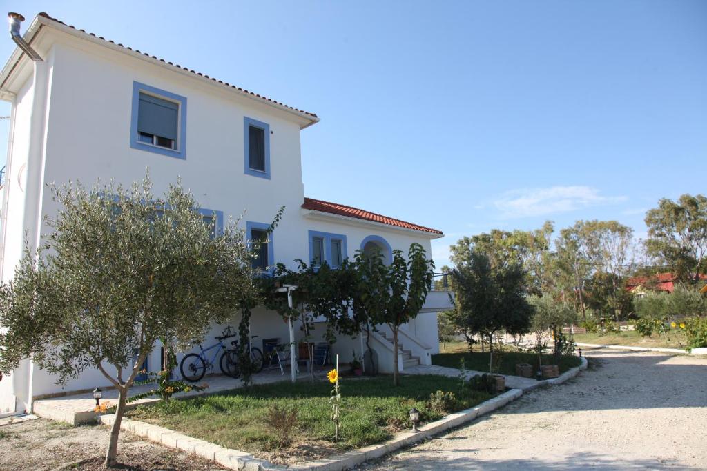 a white house with trees in front of it at Romanos Xi in Xi