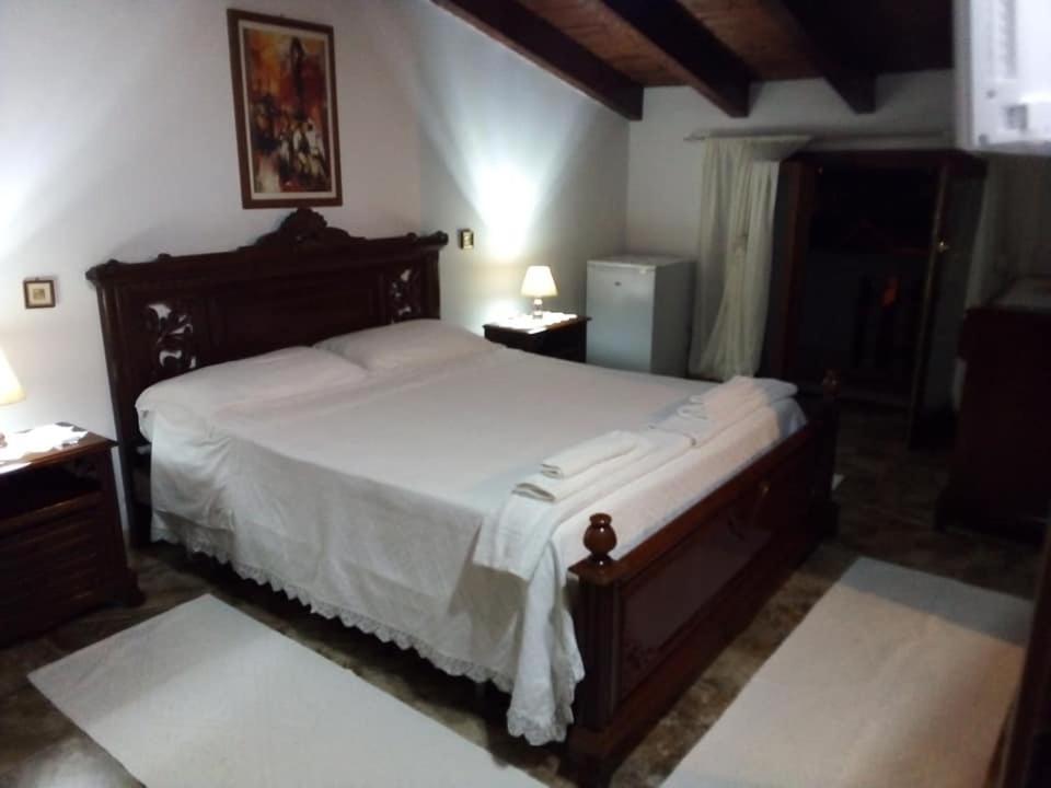 1 dormitorio con 1 cama grande con sábanas blancas en Bed and Breakfast Bellavista, en Olmedo