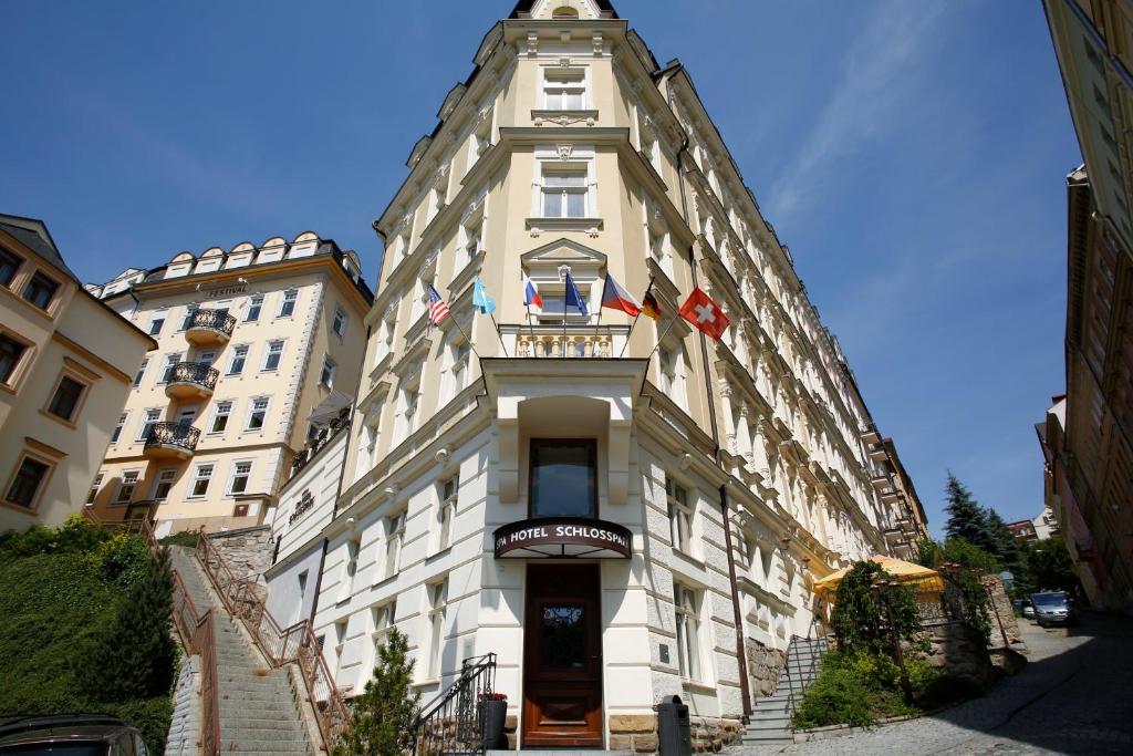 un edificio blanco alto con una torre de reloj. en Spa Hotel Schlosspark, en Karlovy Vary