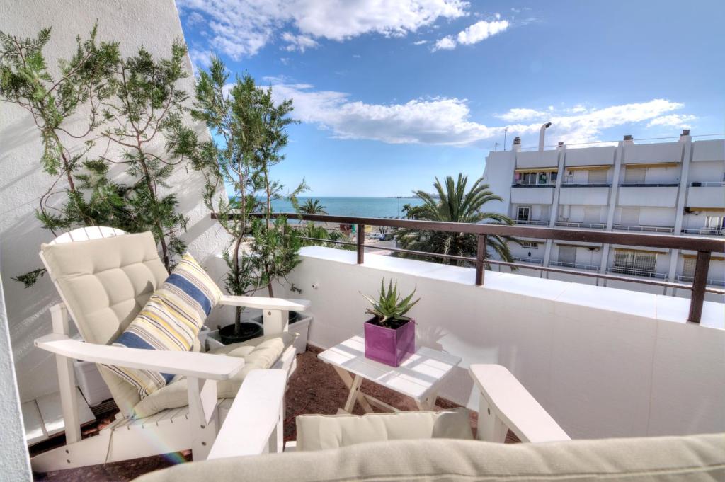 Un balcón con sillas y vistas al océano. en Paradise Beach en Caleta de Vélez
