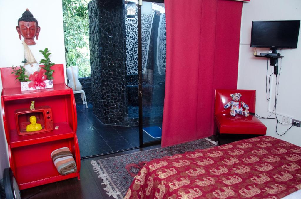 ein Schlafzimmer mit einem roten Bett und einer Dusche in der Unterkunft The Secret Buddha in Medellín