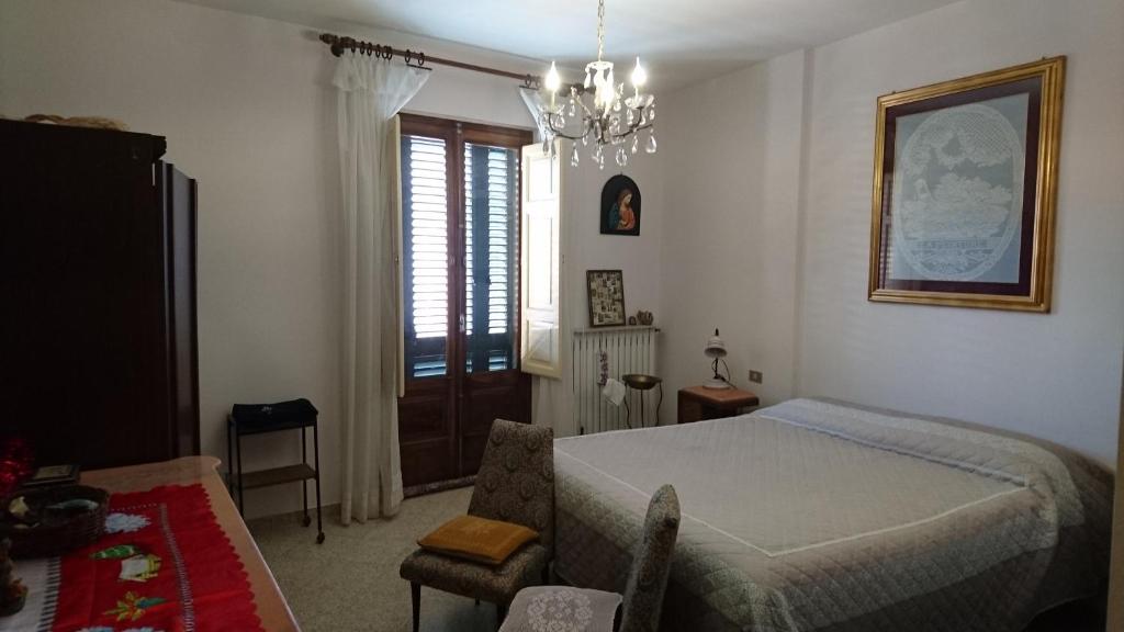 una camera con letto e lampadario a braccio di Casa Vacanze Piazza Apartment 2 a SantʼAndrea di Conza