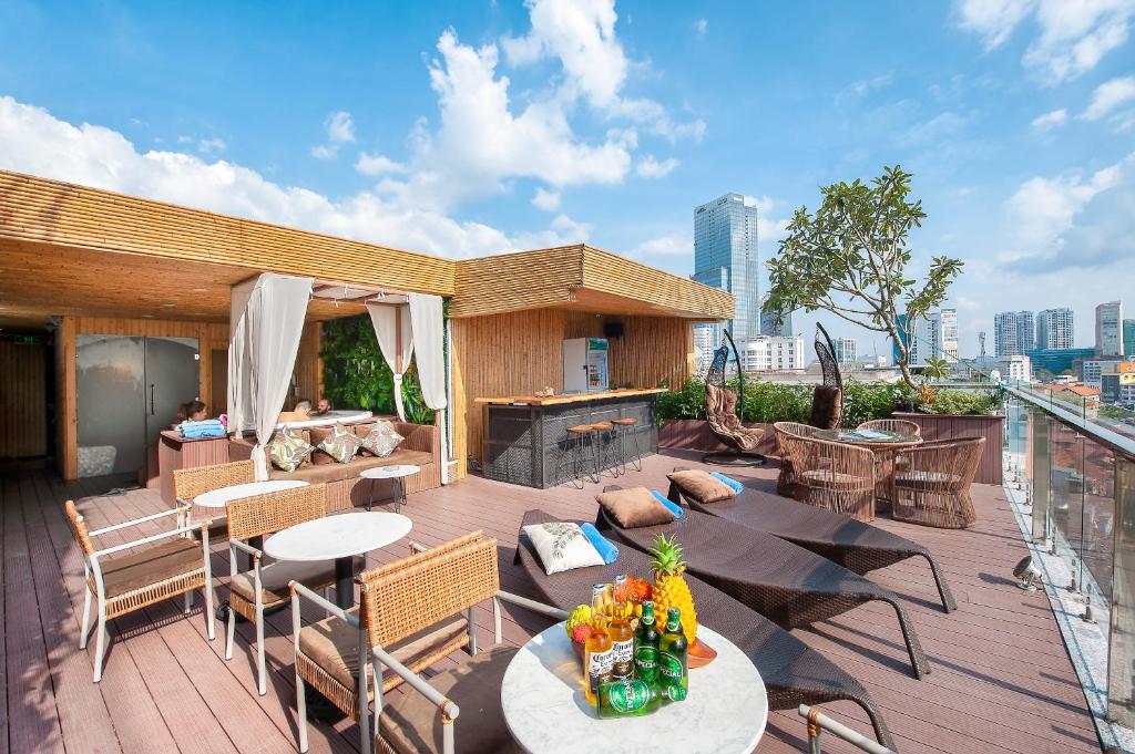 a rooftop deck with tables and chairs and a fireplace at Adora Hotel in Ho Chi Minh City