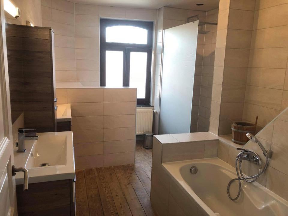 a large bathroom with a tub and a sink at Vakantiewoning Bij de Jep in Bilzen