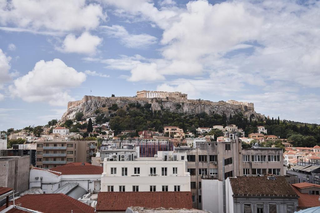 vistas a la acrópolis desde una ciudad con edificios en Perianth Hotel, en Atenas