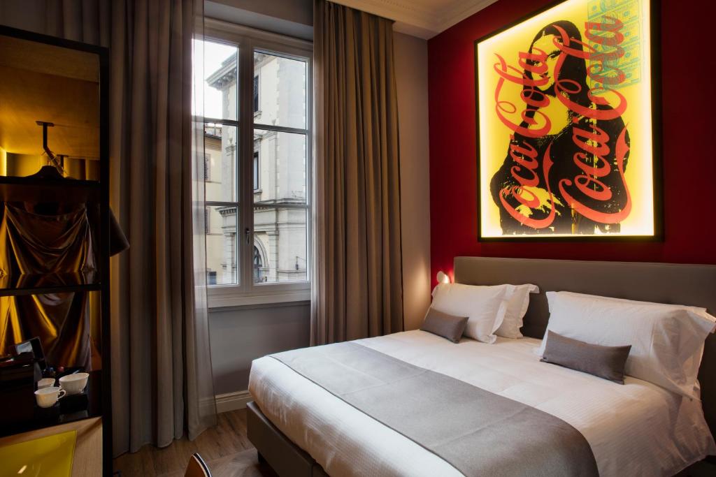 pokój hotelowy z łóżkiem i oknem w obiekcie The Frame Hotel we Florencji