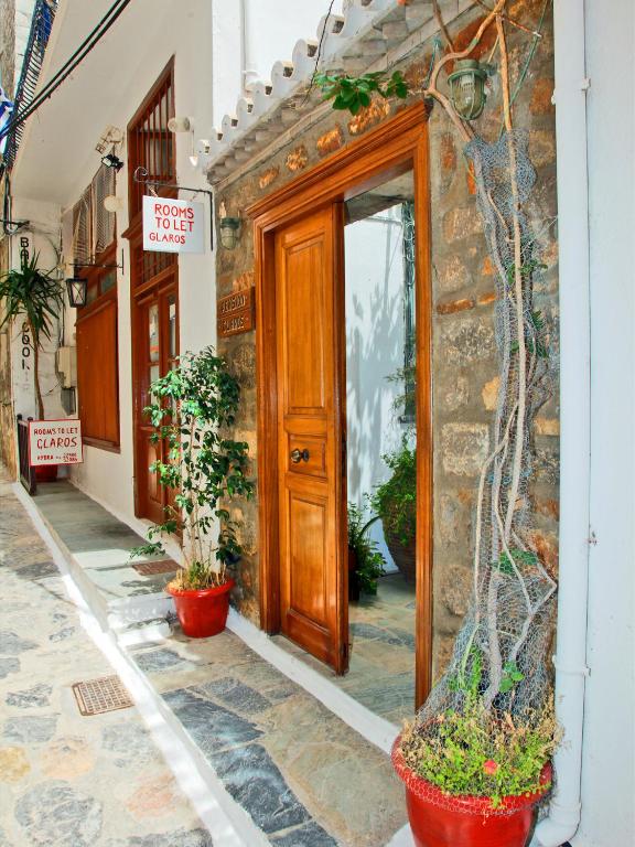 un edificio con una puerta de madera y macetas en el exterior en Glaros Guesthouse, en Hydra