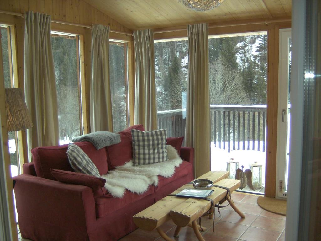 a living room with a red couch and a table at Chalet ?Snow Bunny? in Stadl an der Mur