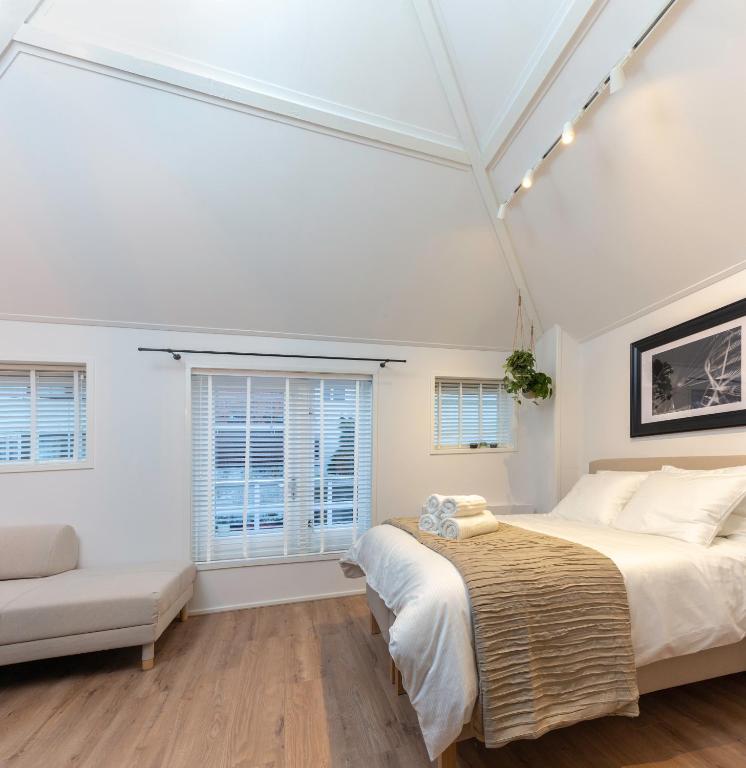 una camera da letto con un letto, un divano e finestre di Design City Center Family double floor apartment studio Delft C38 a Delft