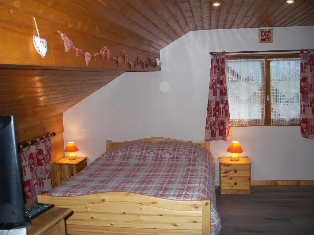 - une chambre avec un lit en bois et 2 tables de chevet dans l'établissement chez nicole, à Giez
