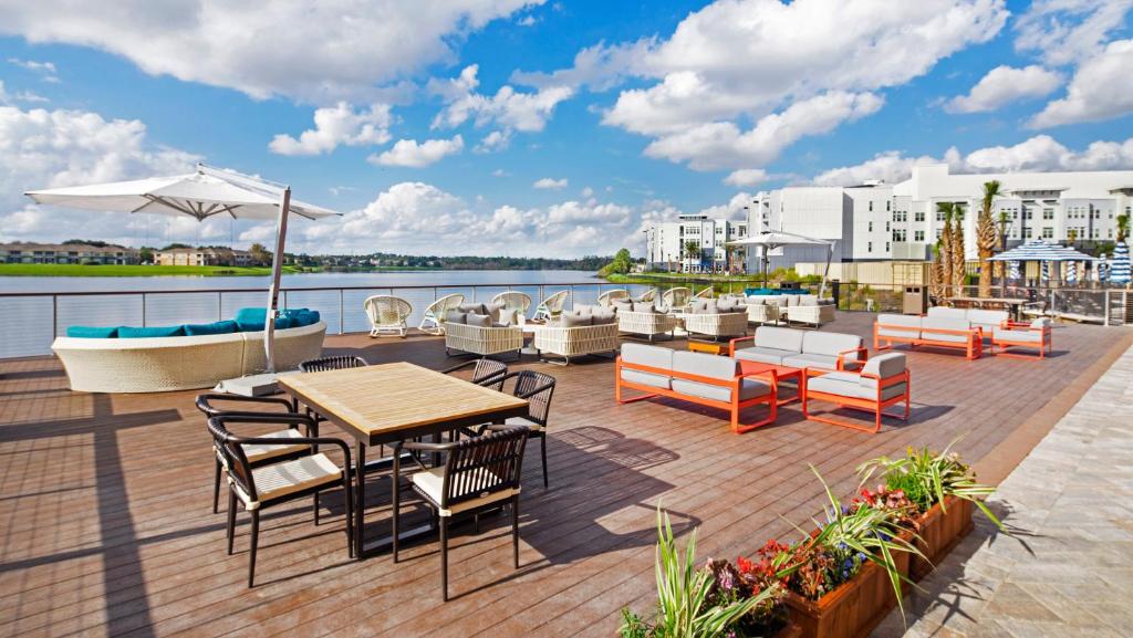 un patio con mesas y sillas y vistas al agua en Hyatt Place Jacksonville St. Johns Town Center en Jacksonville